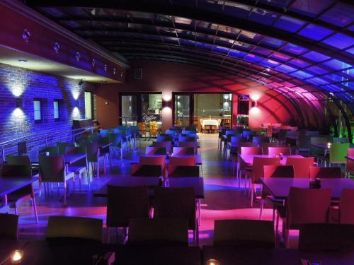 a room with tables and chairs and purple lights at OREA Resort Panorama Moravský kras in Blansko