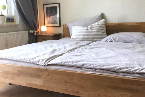 ein Bett mit weißer Bettwäsche und Kissen darauf in der Unterkunft Apartment Anna in Chemnitz