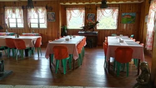 a dining room with tables and chairs and windows at Las vegas lodge and restaurant in Banaue