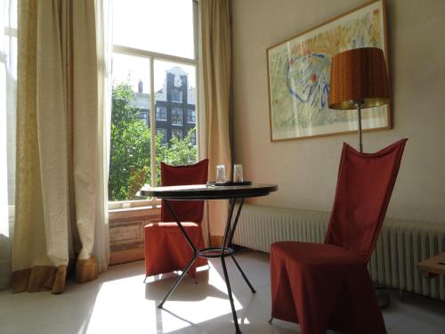 a table and chairs in a room with a window at Casa Luna in Amsterdam