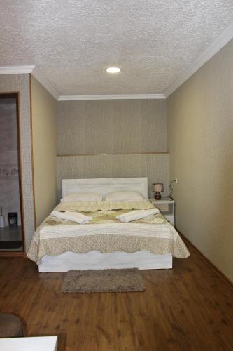 a bedroom with a large bed with a wooden floor at Hotel Rabath in Akhaltsikhe