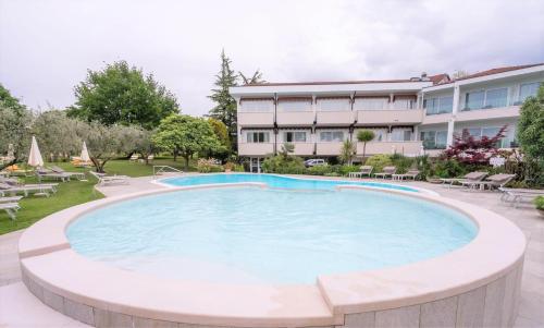 a large swimming pool in front of a hotel at Hotel Giulietta Romeo in Lazise
