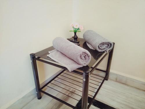 a glass table with towels on top of a chair at Menezes House in Panaji
