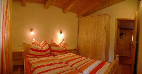 a bedroom with a bed with striped pillows at Ferienwohnung Steiner in Wald im Pinzgau