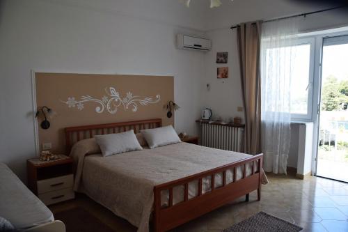 1 dormitorio con cama y ventana grande en villa damecuta B&B, en Anacapri