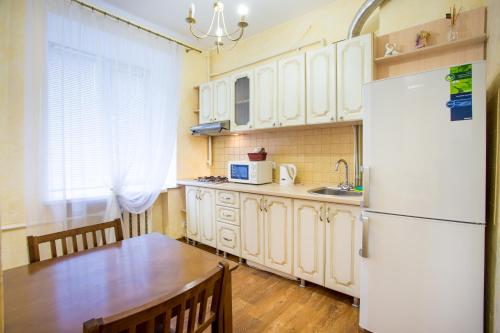 a kitchen with a table and a white refrigerator at Studio on Sobornaya in Mykolaiv