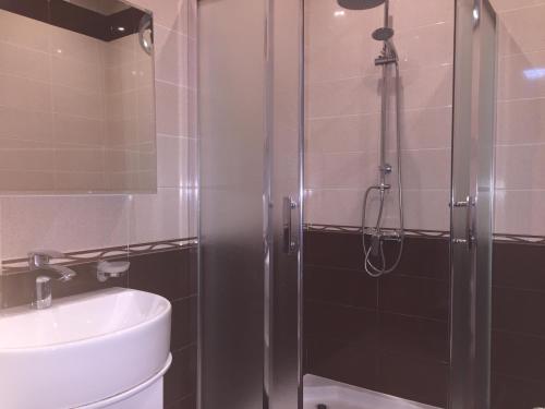 La salle de bains est pourvue d'une douche et d'un lavabo. dans l'établissement Holiday apartment, à Tbilissi