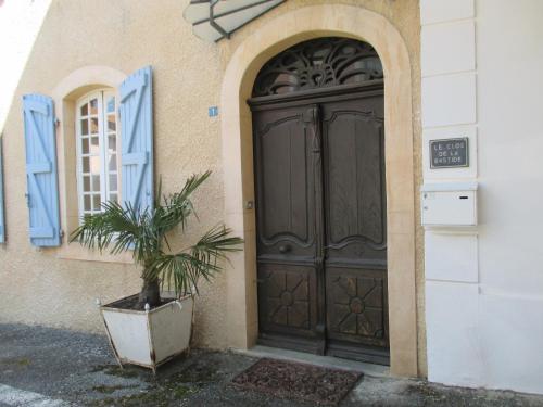 una porta per un edificio con una pianta in vaso davanti di Le Clos de la Bastide a Galan