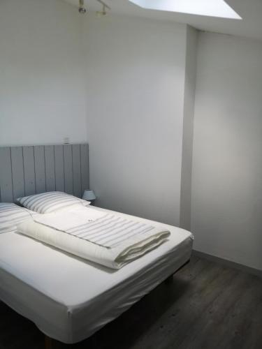 - un lit blanc dans une chambre avec plafond dans l'établissement Duplex Bord Bassin d'Arcachon, à Arès