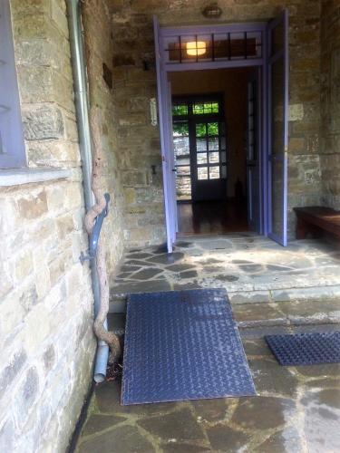 a building with a blue door and a metal grate at Papigo Stonehouse in Papigko