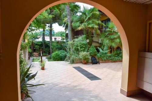 een boog op een binnenplaats met palmbomen en planten bij Debbie's House in Desenzano del Garda