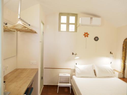 ein weißes Schlafzimmer mit einem Bett und einem Schreibtisch in der Unterkunft Fivos Pension in Chania