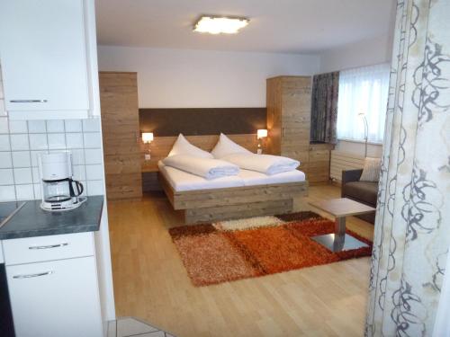 a living room with a couch and a kitchen at Appartements Garni Alpin Live in Samnaun