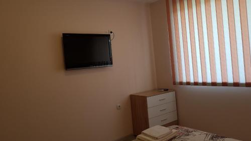 a bedroom with a flat screen tv on the wall at Д и В 2 - D & V 2 Apartment in Sandanski