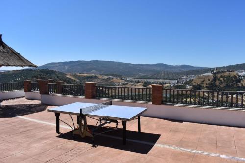 a table on a balcony with a view of the mountains at El Mirador in Iznájar