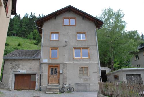 a house with a bicycle parked in front of it at Ferienwohnung Troegligasse in Andermatt