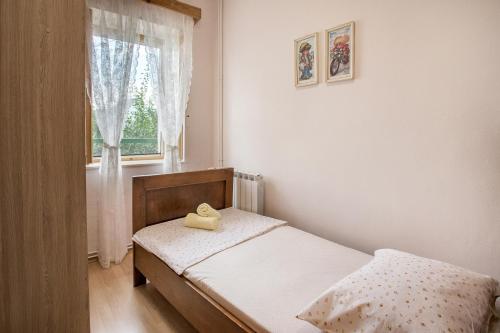 a small bedroom with a bed and a window at Holiday Village Home Kamenica in Kostanje