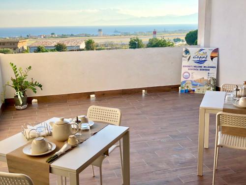 a restaurant with tables and chairs and a view of the desert at Charm Airport in Reggio di Calabria