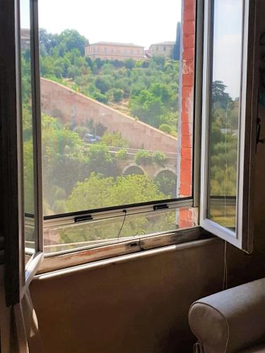 an open window with a view of a building at Finestra sul verde in Siena