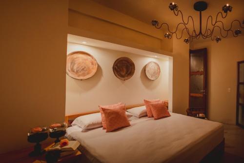 a bedroom with a bed with two plates on the wall at Casa 5 Bed & Breakfast in Palenque