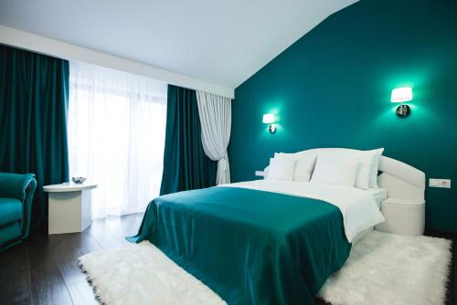 a bedroom with a large bed with a blue wall at Gorgeous Villa in Cluj-Napoca