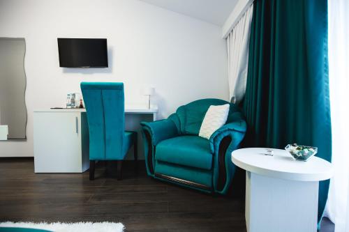 a living room with a blue chair and a table at Gorgeous Villa in Cluj-Napoca