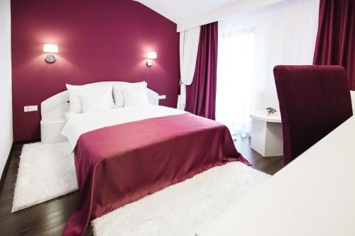 a bedroom with a bed with a purple wall at Gorgeous Villa in Cluj-Napoca