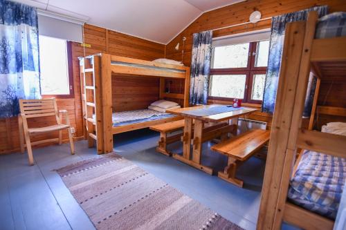 キルピスヤルヴィにあるキルピシャーベン レトケイリケスクス コテージズの二段ベッド、テーブル、デスクが備わる客室です。