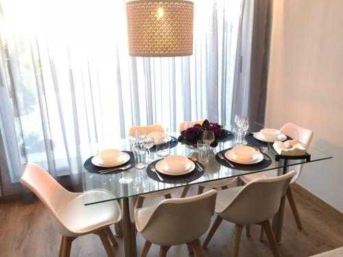 a dining room table with white chairs and a glass table and chairsktop at Povoa do Mar in Póvoa de Varzim