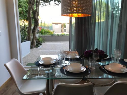 a glass table with plates and glasses on it at Povoa do Mar in Póvoa de Varzim