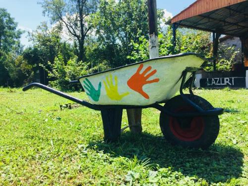 a wooden wheelbarrow with colorful hands painted on it at Lazuri Keria Family Guesthouse in Khoni