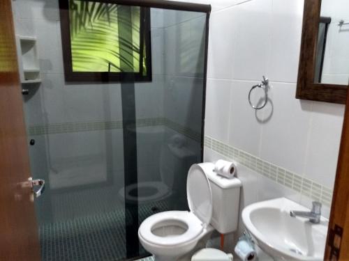 een badkamer met een toilet en een wastafel bij RC Sol de Boicuçanga - Chalés in Boicucanga