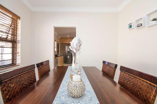 a dining room with a table with a vase on it at King Guest Lodge in Port Elizabeth