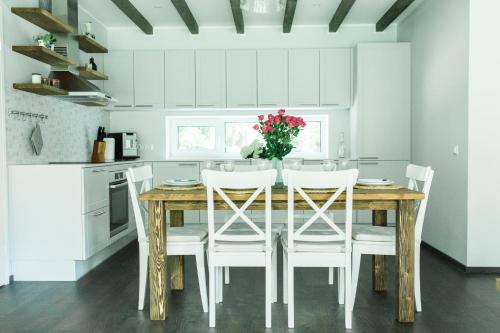 a kitchen with a wooden table and white cabinets at The Peaceful Vacation in Muratsi