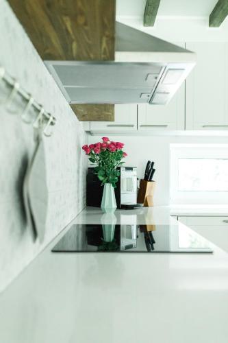 a white kitchen with a glass table with a vase of flowers at The Peaceful Vacation in Muratsi