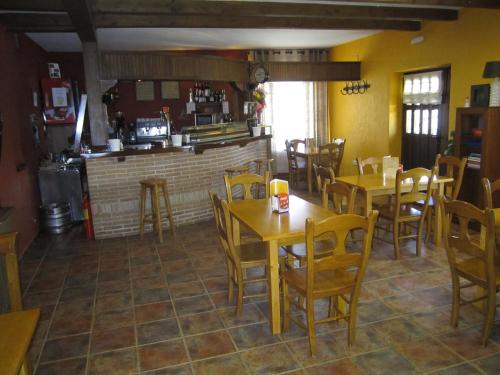 a restaurant with tables and chairs and a bar at Hotel Rural La Dehesilla in Barajas de Gredos