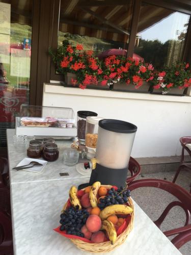 una cesta de fruta en una mesa con un jarrón en Hôtel les skieurs, en Bellevaux