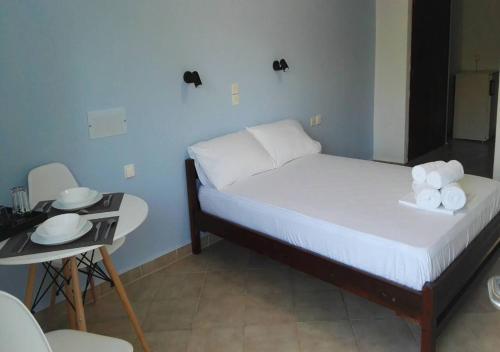 a small bedroom with a bed with towels on it at Creta Star Apartments in Agia Galini