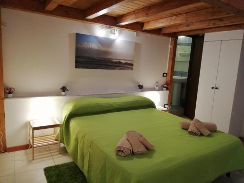 ein Schlafzimmer mit einem grünen Bett mit zwei Handtüchern darauf in der Unterkunft Dimora 394 in Catania