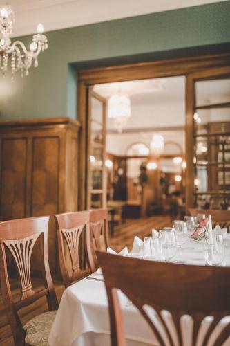a dining room with a table and chairs and a chandelier at Kurhotel & Hotel Mozart in Bad Gastein