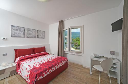 a bedroom with a red bed and a desk and a window at la Luna nel Lago in Roe