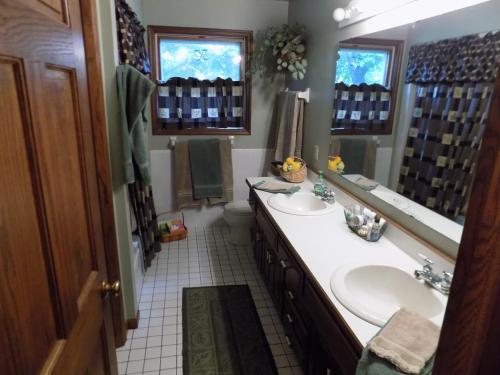 een badkamer met 2 wastafels en een grote spiegel bij StoneWall House in Lake Elmo