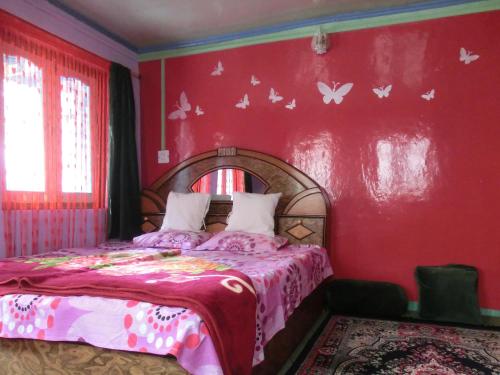 - une chambre avec un lit aux papillons sur le mur dans l'établissement Homestay Hari Parbat, à Srinagar