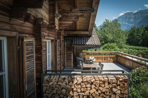 a deck with a table and chairs on a house at Hotel-Restaurant Burgseeli in Goldswil