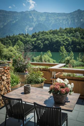 a table with two chairs and flowers on a patio at Hotel-Restaurant Burgseeli in Goldswil