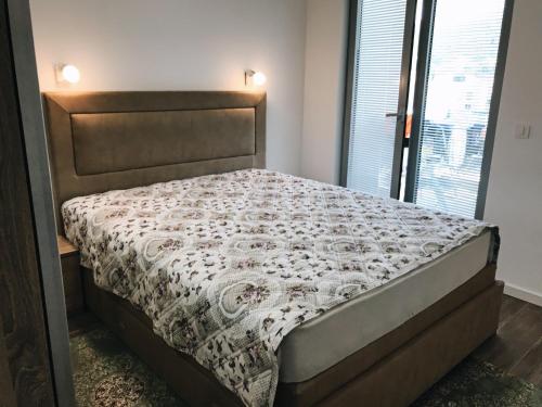a large bed in a bedroom with a bedspread at Apartmani Belma in Dobra Voda