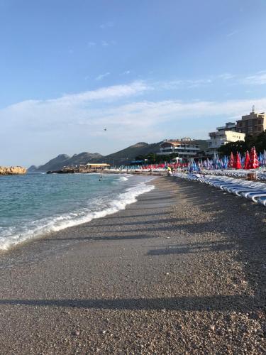 a beach with umbrellas and the ocean at Apartmani Belma in Dobra Voda