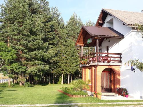 ein Haus mit einem Balkon an der Seite in der Unterkunft Rooms Danica in Donji Babin Potok