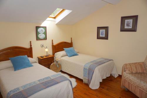 una camera con due letti e un divano di Hotel Rural La Pista a Vega de Rengos