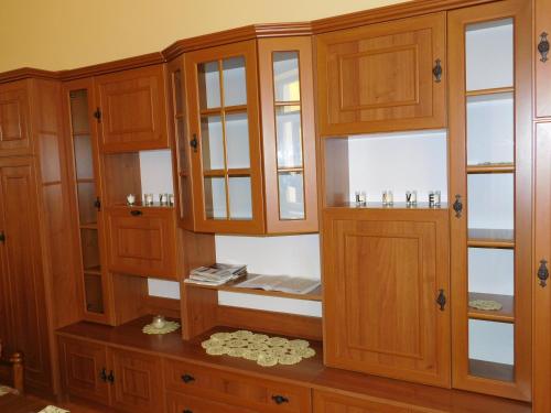 un armario de madera con puertas de cristal y una mesa de madera en Bodzavirág Vendégház en Hegykő